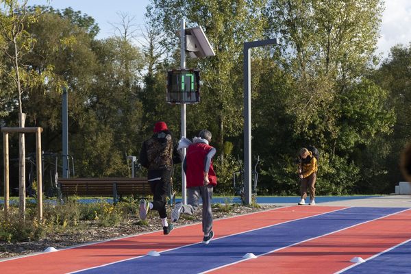 Due corridori sulla pista di atletica a Saint-Dizier, con un dissuasore di velocità EVOLIS Vision che mostra una velocità di 17 km/h.